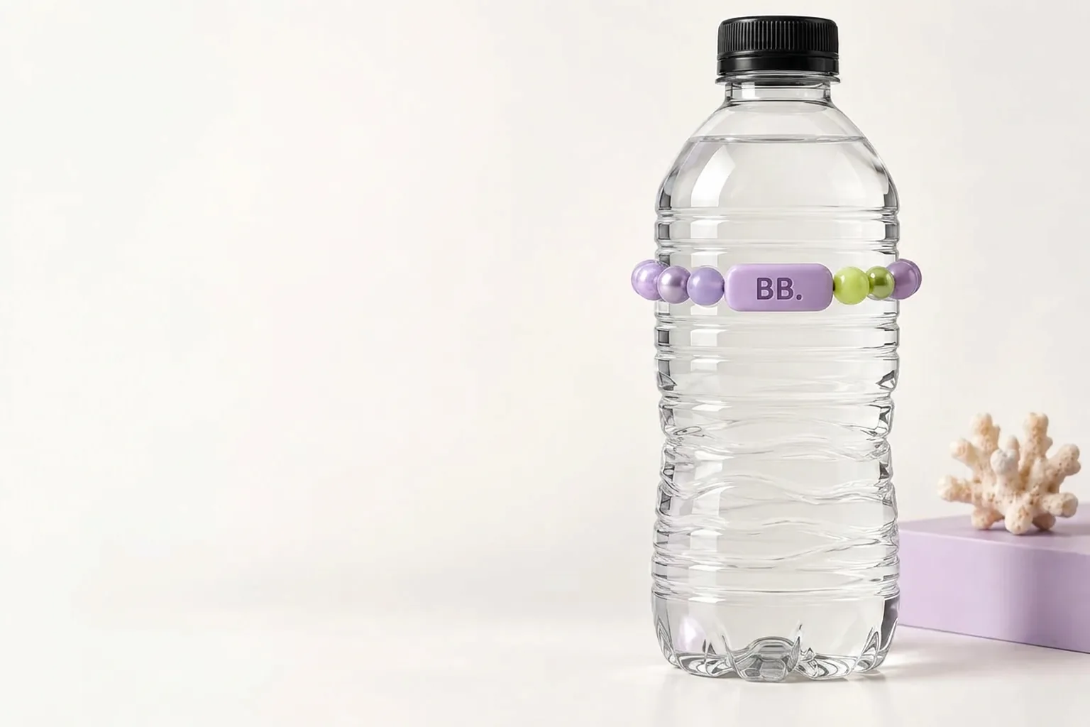 A clear water bottle wearing a lilac band with an embossed Bottle Bracelets tile and small lime accent zone